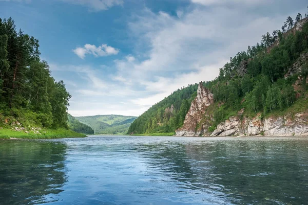 Sibirya 'nın manzarası. Kiya Nehri, dağ kıyıları ve Kemerovo bölgesindeki yeşil ormanlar. Mavi gökyüzü ve bulutlu gündüz manzarası.