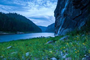 Landscapes of Siberia. Evening landscape at sunset. Mountains, forest, river and water and waterfall at long exposure. Kemerovo region. Russia 