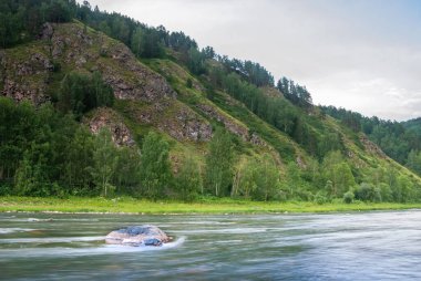 Sibirya 'nın manzarası. Kiya Nehri, dağ kıyıları ve Kemerovo bölgesindeki yeşil ormanlar. Mavi gökyüzü ve bulutlu gündüz manzarası.
