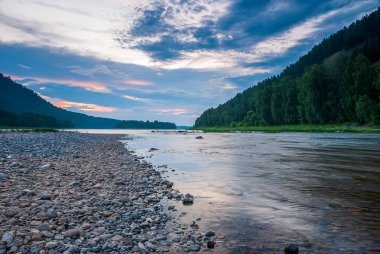 Sibirya 'nın manzaraları. Gün batımında akşam manzarası. Dağlar, orman, nehir ve su uzun vadede. Kemerovo bölgesi. Rusya 