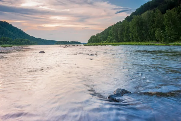 Sibirya 'nın manzaraları. Gün batımında akşam manzarası. Dağlar, orman, nehir ve su uzun vadede. Kemerovo bölgesi. Rusya 