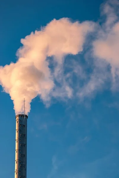 Industrial smoke from chimney on blue sky