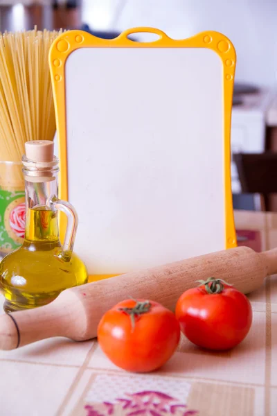 Tomatoes, spaghetti and  menmu board on table — Stock Photo, Image