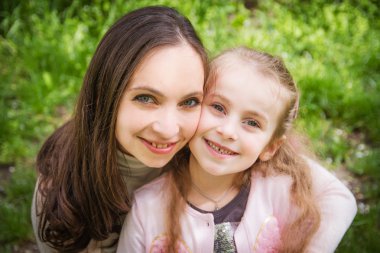 Anne kızını kucaklıyor.