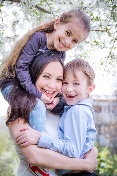 Mãe feliz e dois filhos abraçando — Fotografia de Stock