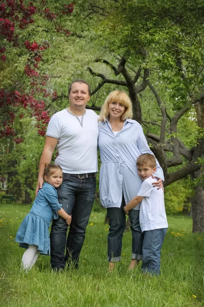 Família feliz com dois filhos jardim — Fotografia de Stock