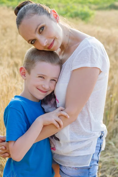 Mother and son hugging in wheat field — Stock Photo, Image