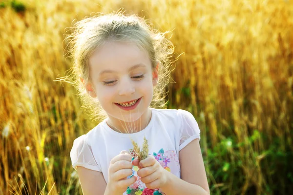 Menina jogando no trigo arquivado — Fotografia de Stock