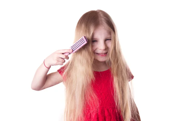 Upset girl combing tangled blonde long hair — Stock Photo, Image