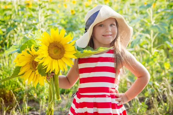 Meisje bedrijf zonnebloemen onder veld — Stockfoto