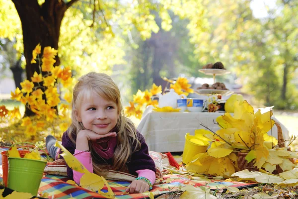 野餐在秋天的树木下的小女孩 — 图库照片