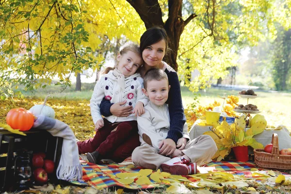 Mother with son and daughter under autumn trees — Stock Photo, Image