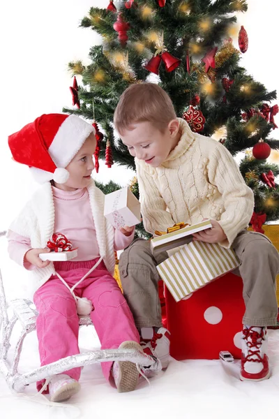 Soeur et frère montrant des cadeaux de Noël — Photo