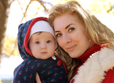 Sonbahar parkta oynarken anne ve bebek kız