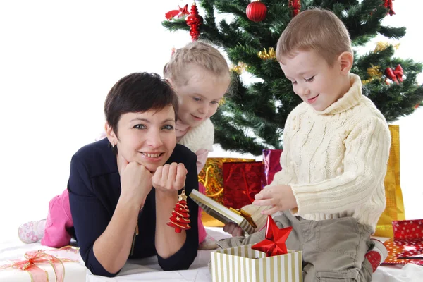 Madre y dos hijos abren regalos — Foto de Stock