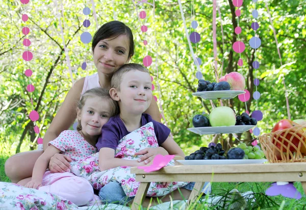 Mamma med två barn på picknick — Stockfoto