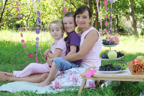 Mamma med två barn på picknick — Stockfoto