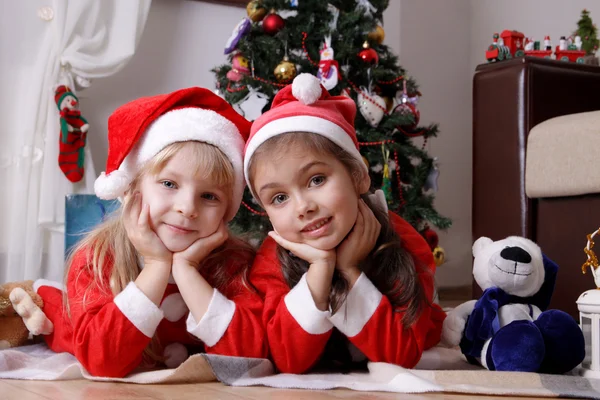 Meninas sob a árvore de Natal — Fotografia de Stock