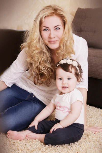 Madre e bambina seduta su tappeto — Foto Stock