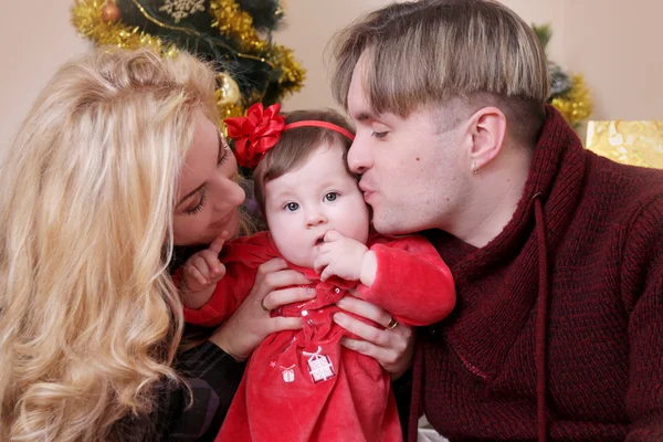 Mãe e pai beijando seu bebê menina — Fotografia de Stock