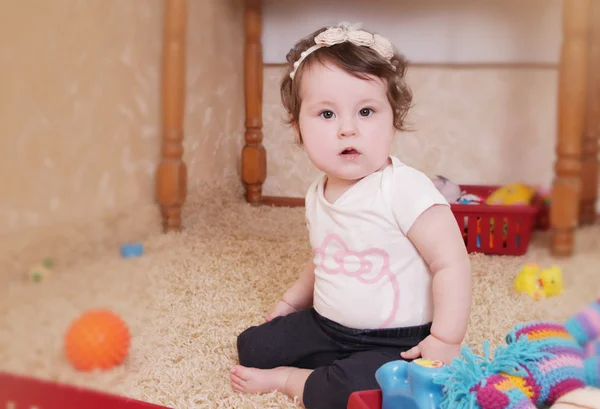 Tio månader baby flicka leker med leksaker Stockbild