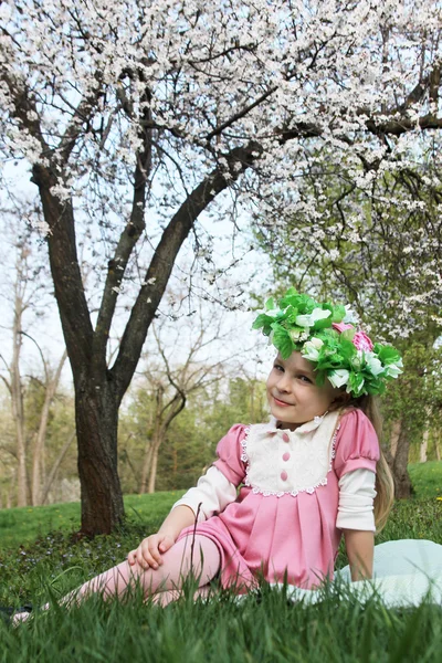 Usměvavá holčička s květinovým věncem — Stock fotografie