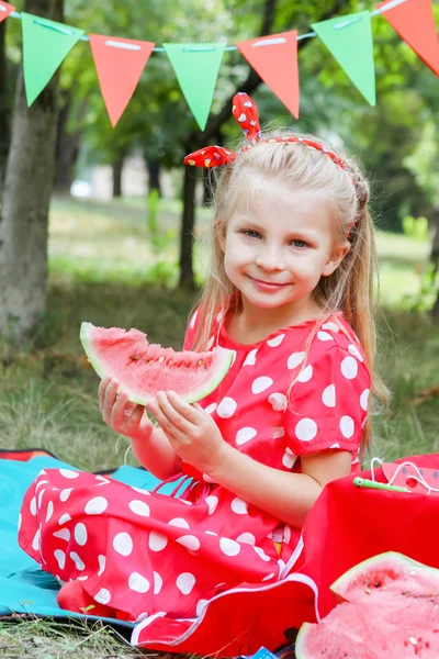 Menina em vermelho com melancia no piquenique — Fotografia de Stock
