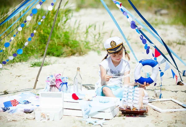 Fille dans une casquette sur la plage avec des décorations — Photo