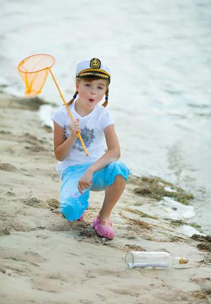 Mädchen mit Mütze am Strand fand Flasche mit Botschaft — Stockfoto