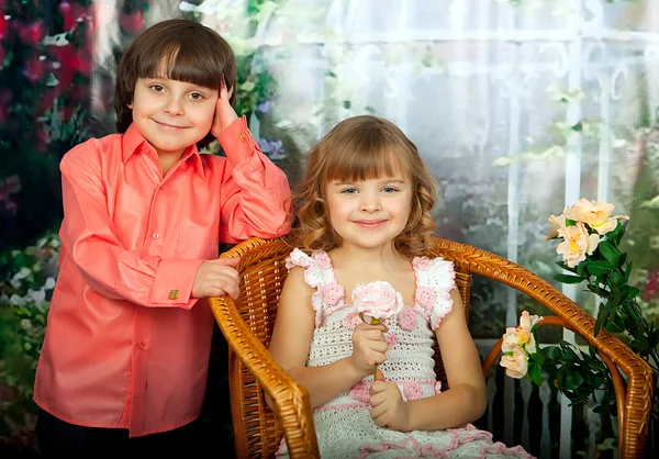 Smart Mädchen und Junge mit Blumen in eleganten Kleidern — Stockfoto