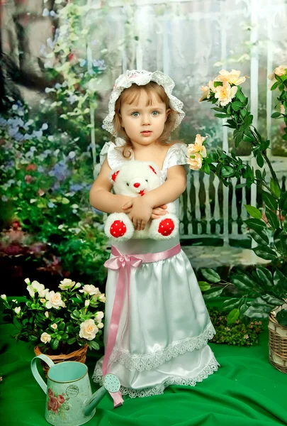 Mooi meisje in een hoed met een lacy witte beer op een tuin backg — Stockfoto
