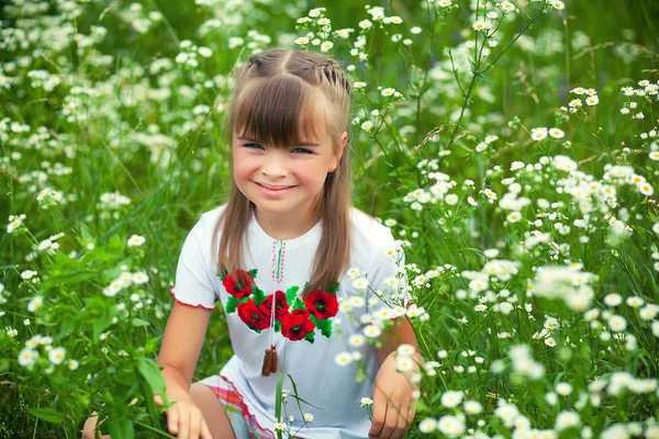Veselá dívka v ukrajinských výšivky na květinové pozadí — Stock fotografie