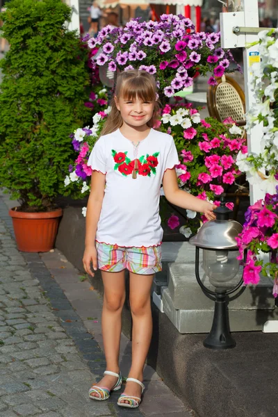 Cheerful girl in Ukrainian embroidery on the floral background — Stock Photo, Image