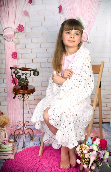 Симпатична маленька дівчинка зі старим телефоном, загорнутим у ніжну ковдру сі Ліцензійні Стокові Зображення