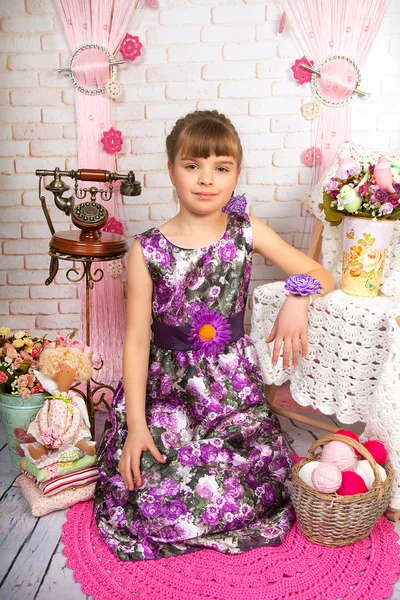 Menina adolescente em um belo vestido roxo sentado na sagacidade cenário Imagens Royalty-Free