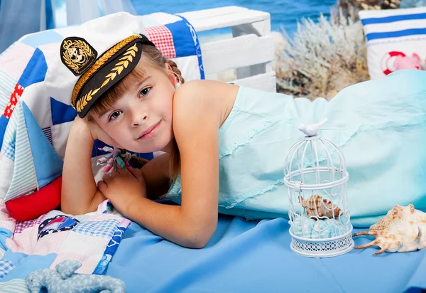 Girl in a blue dress and white cap on a background seascape — Φωτογραφία Αρχείου