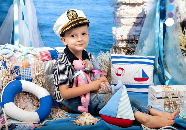 Niño pequeño con una camiseta a rayas gorra de capitán en el paisaje del mar —  Fotos de Stock