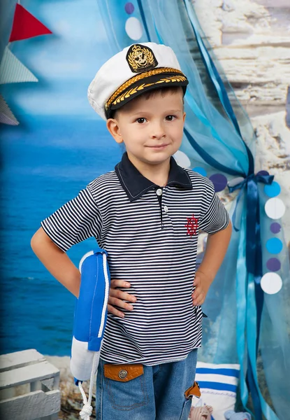 Um garotinho de camisa listrada com uma corda salva-vidas na cena do mar — Fotografia de Stock