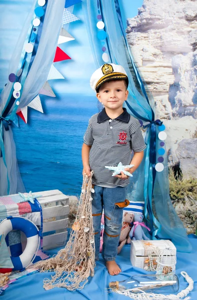 En liten pojke i en randig skjorta med en livlina i havet scen — Stockfoto