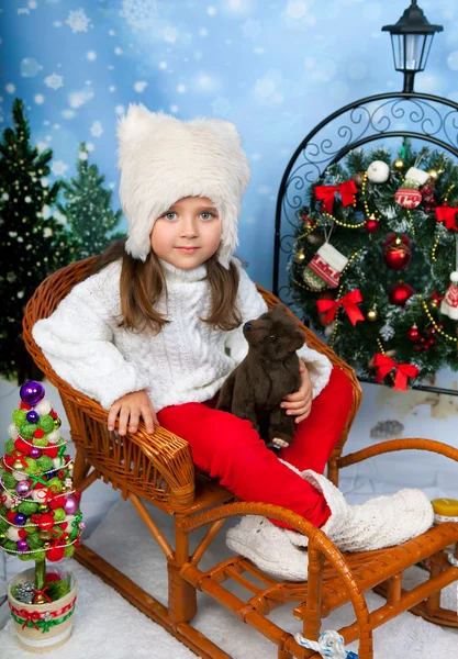 Retrato de uma menina bonita em um boné branco e camisola de malha sentar — Fotografia de Stock