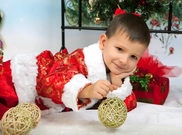 Beautiful little boy in a red suit in the New Year decorations l — Stock Photo, Image