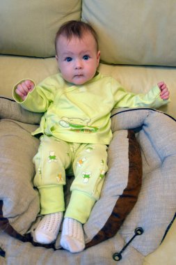 Bir yaşına kadar kanepede oynayan küçük bir çocuk..