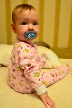 Bir yaşına kadar kanepede oynayan küçük bir çocuk..