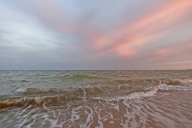 Azov Denizi sahilinde güzel bir akşam gün batımı. Gökyüzünün ve denizin renkli renkleri.