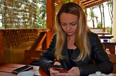 Restoranda elinde akıllı bir telefonla güzel bir kız..