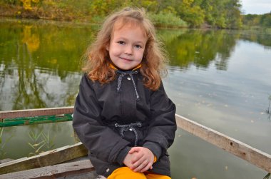 Güzel bir kız çocuğu sonbahar ormanında yürüyor..