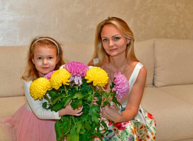 Güzel çiçek buketleri olan anne ve kızı..