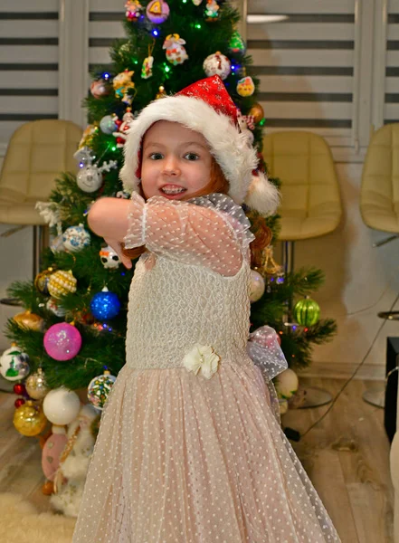 圣诞佳节前夕 穿着节日礼服的漂亮小女孩就在圣诞树旁 — 图库照片