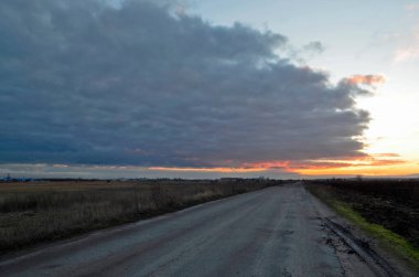 Güzel, bulutlu ve ilkbahar günbatımının erken saatlerinde tarlalarda.