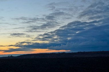 Güzel, bulutlu ve ilkbahar günbatımının erken saatlerinde tarlalarda.